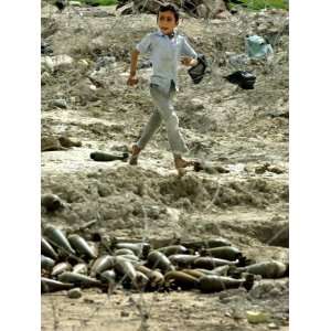  An Iraqi Schoolboy Walks Past a Pile of Unexploded Mortar 