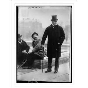   , in coat and top hat. Two unidentified men seated at